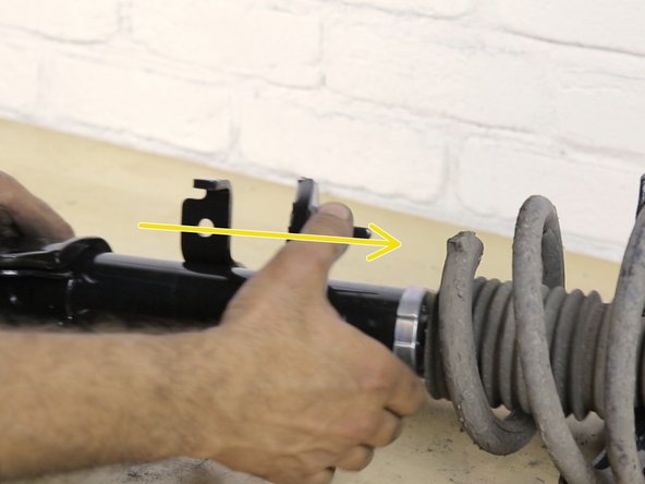 Positionner le ressort contre la buté sur l'amortisseur