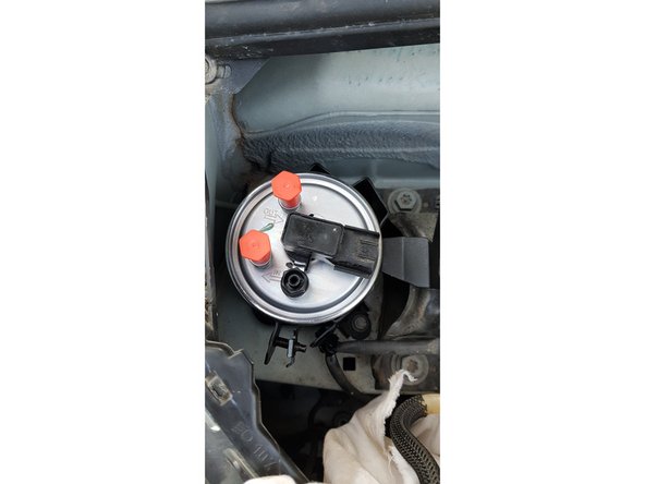 Reposez le filtre dans son logement puis reconnectez les durites et le connecteur.