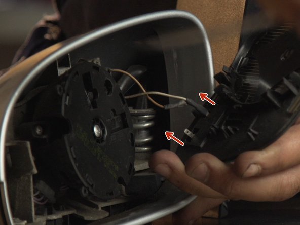 Avec un petit tournevis plat, détacher les deux connecteurs du miroir