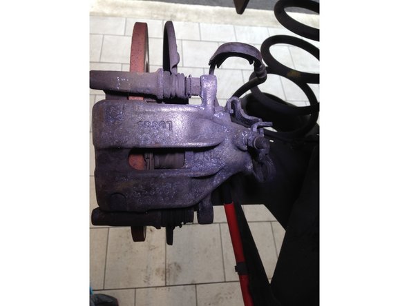 Une fois les deux vis de 13 retirer, retirer l'étrier en tirant vers le haut