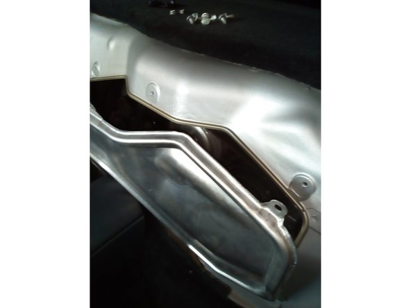 Reposer la trappe moteur et la fixer avec les 7 vis et 2 écrous à l'aide de la clé de 10 mm.