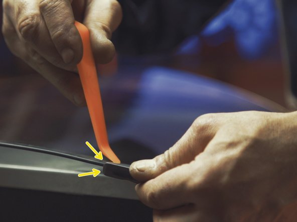 
Using a spatula, lever up both sides of the guide at the top of the window.
