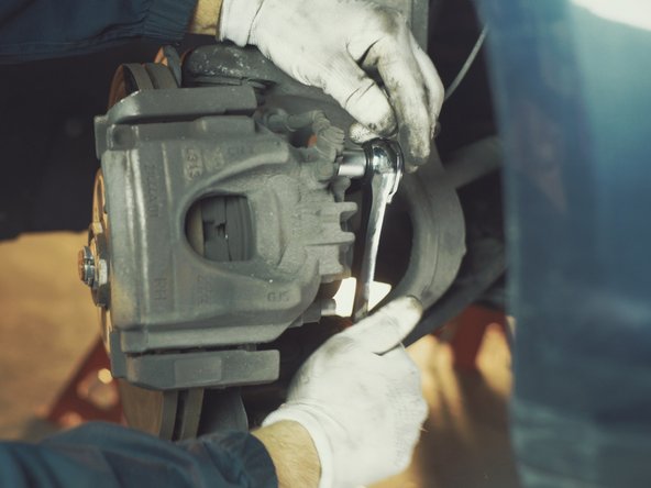 A l'aide d'un cliquet et d'une douille allen de 7 dévisser les colonnettes de l'étrier sans les retirer