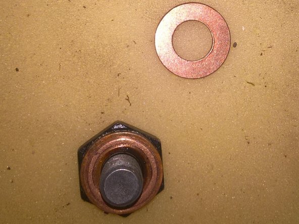 Mettre un récipient et desserer avec une clé à douille de 21 le bouchon de vidange sur le carter. Remplacer le joint en cuivre par un joint neuf.