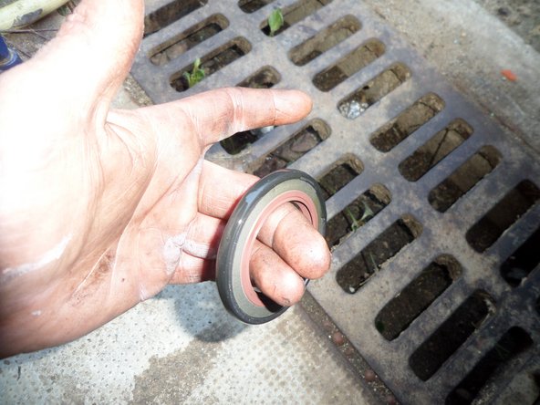 Poser le joint spi à l'aide du cache poussière en tapotant doucement à l'aide d'un maillet tout autour du cache de façon régulière afin de le rentrer délicatement. Quand le cache est en butée sur le carter moteur, vérifier le bon positionnement du joint spi.