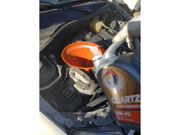 à l'aide d'un entonnoir, faire le plein d'huile 5W40