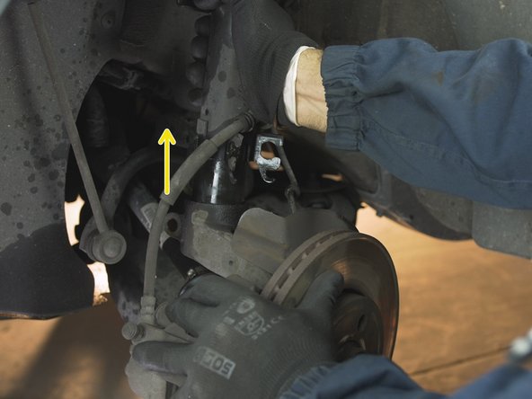 Tirer l'amortisseur vers le haut tout en faisant levier avec le bras