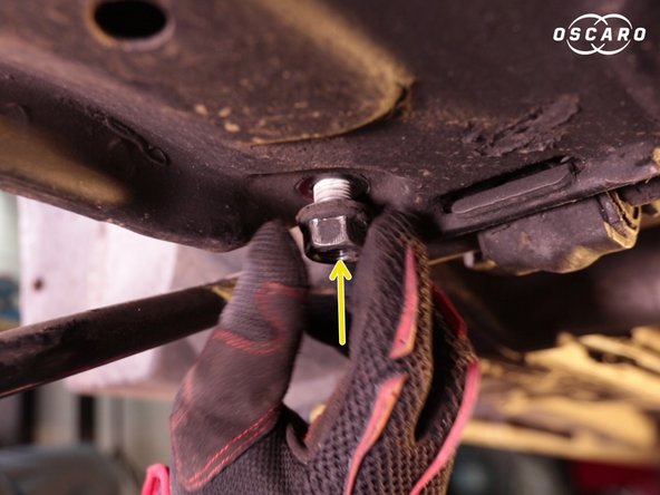 Dévisser la vis de support du triangle en la bloquant avec un cliquet sur le dessus et en dévissant depuis le dessous de la voiture