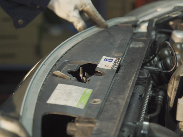 Replacer le dessus du pare-choc en faisant passer le système d'ouverture