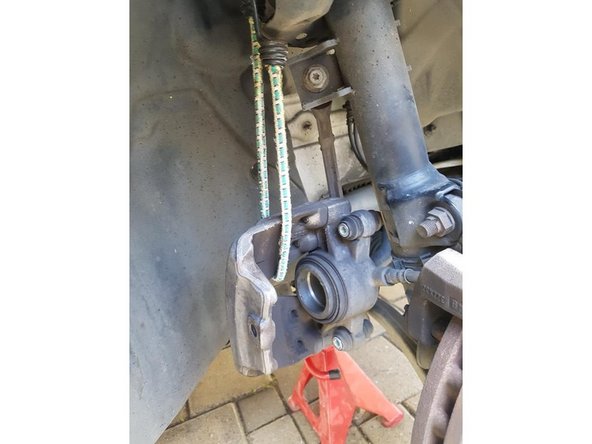 Dégagez l'étrier et accrochez le à l'amortisseur a l'aide d'un tendeur ou d'un autre moyen.( Attention à ne pas abimer le flexible de frein)