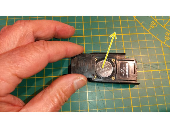 Extraire l'ancienne pile en la faisant glisser vers le haut flèche jaune.