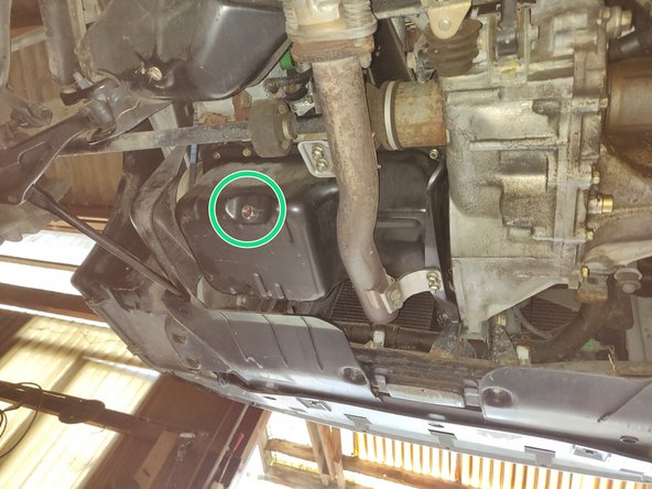 Localiser le bouchon de vidange sous la voiture au niveau du carter d'huile