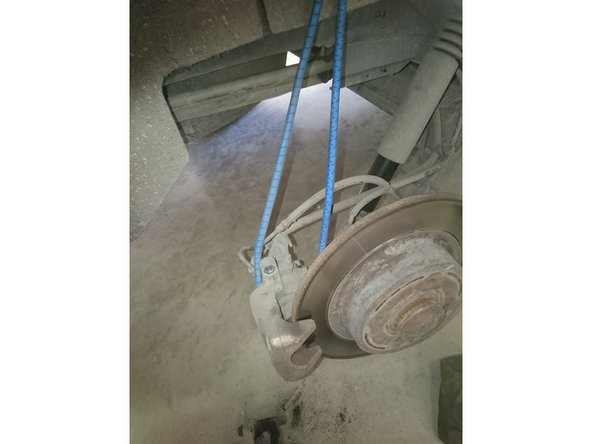 Dégager l'étrier en le tirant vers l'extérieur du disque. en rouge photo 2