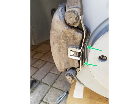 Remettre en place l'agrafe en la positionnant et en appuyant avec les deux mains à l'emplacement des flèches vertes afin de re positionner le plot dans son emplacement