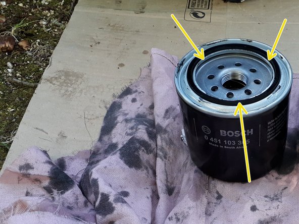 Mettre un petit peu d'huile sur le joint du nouveau filtre et l’étaler avec le doigt sur la totalité du joint