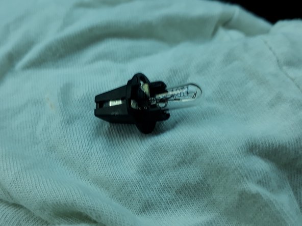 insérer à la main la nouvelle ampoule dans le support plastique noir