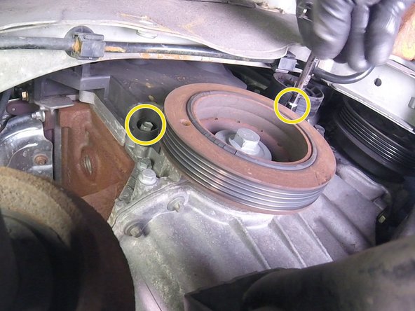 Faire pivoter la biellette du berceau  pour accéder aux vis du bas du carter en plastique