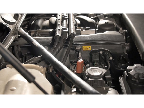 Soulever et tirer délicatement sur le cache moteur puis lever la barre pour faciliter le passage