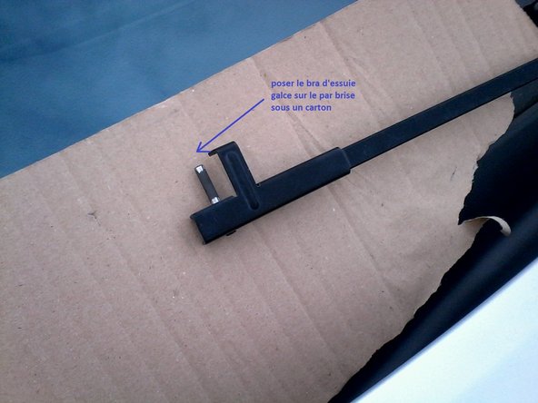 Poser le bras d'essuie sur le par brise sous un carton