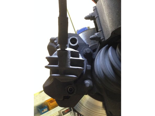 Retirer les caches de vis sur l'étrier