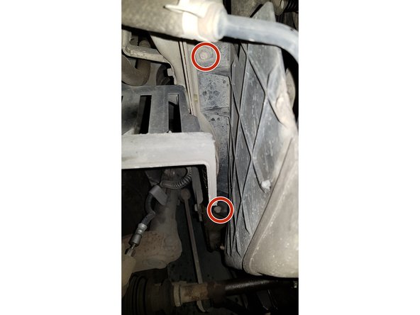 Passez sous la voiture pour retirer les 2 vis puis le carter.