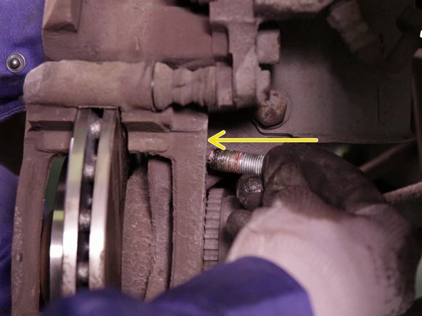 
Replace the caliper, and insert the screws starting with the top one. Tighten them using the ratchet and the 18 socket.
