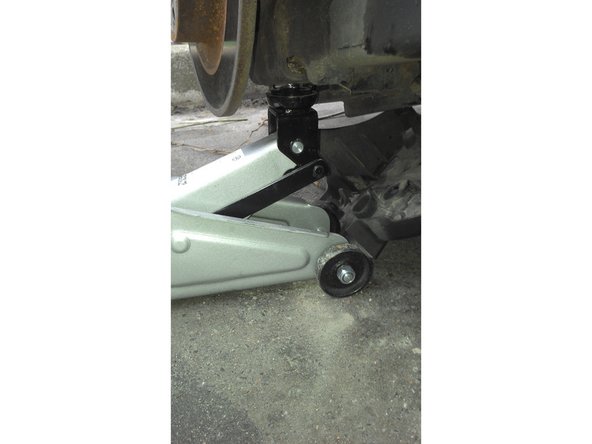 Soulevez la coupelle du ressort à l'aide du cric (3cm environ) et commencer à dévisser en haut et en bas (clé à cliquet douille de 18). Retirez la vis en haut puis en bas.