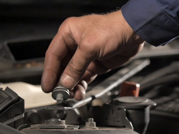 A l'aide d'un cliquet et d'une douille Torx E14 desserrer la vis de la barre de renfort