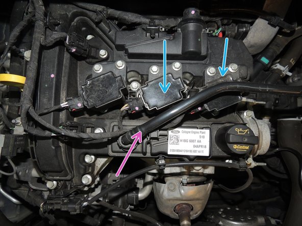 Répéter l'opération pour les deux autres bougies. Il est possible de retirer le tuyau de recirculation des vapeurs d'huile (flèche rose) pour faciliter le démontage de la 3ème bobine.