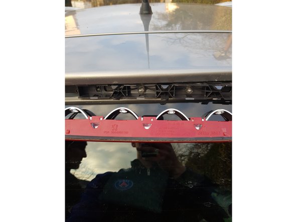 Maintenant, 3 clips sont présent sur le dessus du plastique du feu stop, utilisez un petit tournevis plat pour appuyer sur les clips et tirer vers vous pour séparer les 2 parties du troisième feu stop.