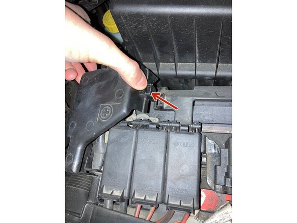 Détachez le cache de la borne positive. (Juste une pression sur l'attache suffit)