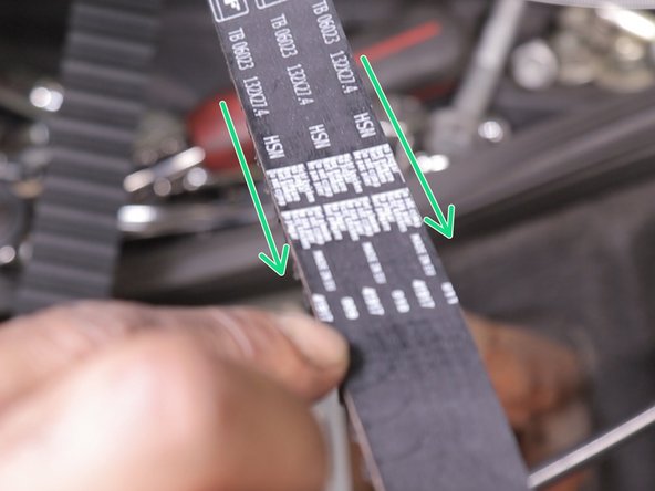 Présenter la courroie avec les inscriptions dans le sens de la lecture