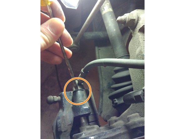 Enlever les caches en plastique avec un petit tournevis. Il y en a deux derrière l'étrier (un en haut et un en bas).