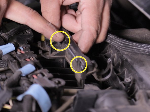 Appuyer sur les deux languettes de chaque coté du support de la pompe d’Amorçage placé devant la boite à, air puis retirer le