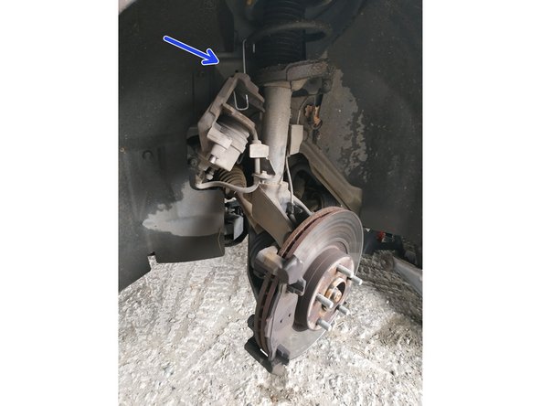 lever et suspendre l'étrier sur le ressort d'amortisseur