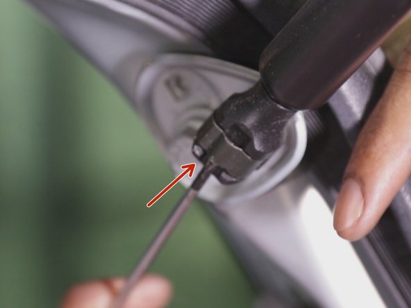 Placer le tournevis plat entre le clips et l'attache retenant le bas du vérin