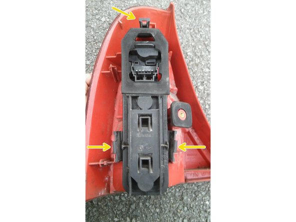 Déclipser le porte ampoule en poussant les attaches plastiques vers l'intérieur. Il y en a 3 au total.