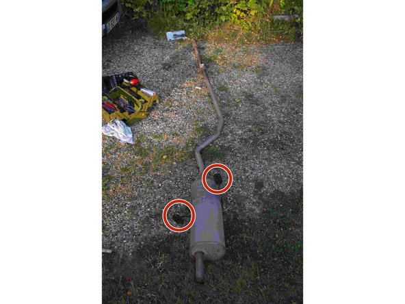 Il faut maintenant déposer le pot d'échappement ainsi que le tube qui le lie à la partie que nous voulons changer. Le pot d'échappement est tenu uniquement par 2 silent block (photo 2).