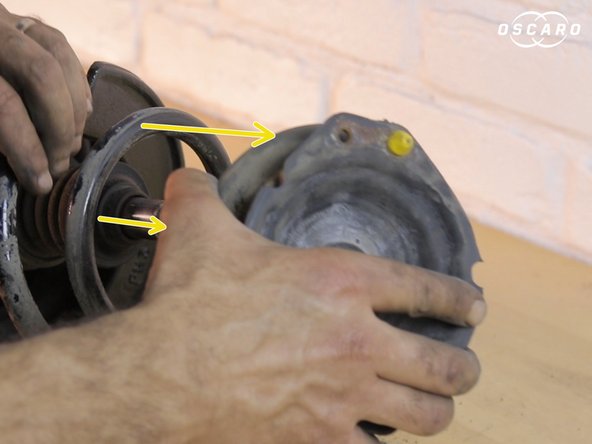 S'assurer que le ressort soit toujours bien engagé dans le compresseur avant de finir de retirer l'écrou de la coupelle.