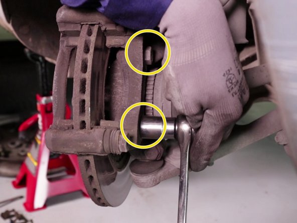 
Using the ratchet and socket, loosen the 2 caliper bracket screws, starting with the bottom one.
