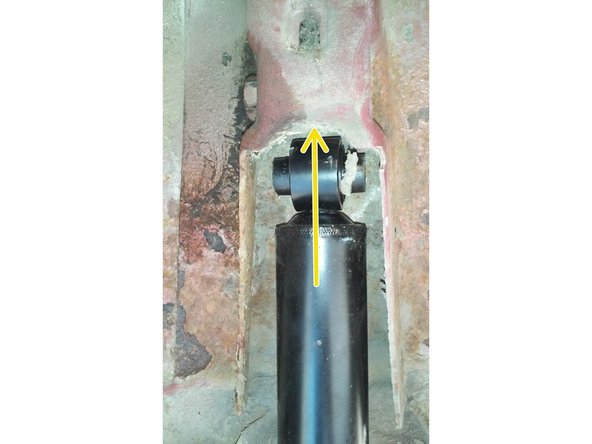 Enfiler le haut de l'amortisseur dans son emplacement et mettre la vis.