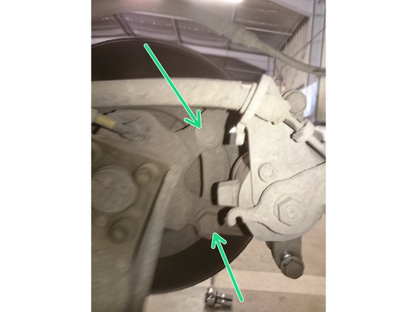 Desserrer les deux boulons du support d'étrier en vert. Photo 1