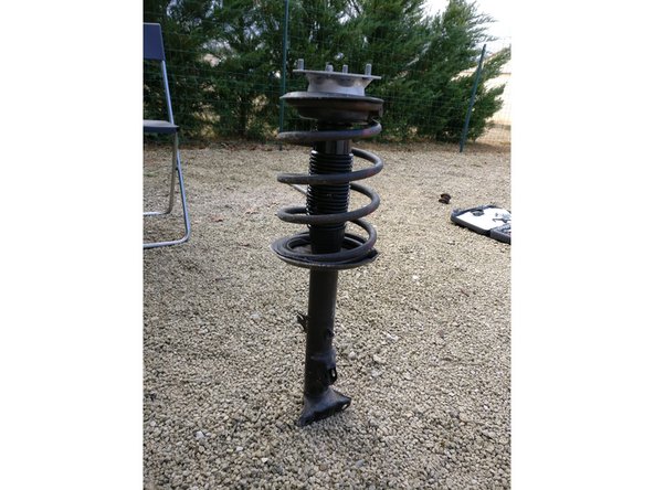 Bien mettre le ressort dans l'encoche de l'amortisseur avec ses caoutchouc avant de desserrer les compresseurs