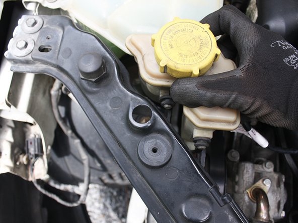 Éloigner le bocal de liquide de direction assistée avec son conduit de la zone de travail.