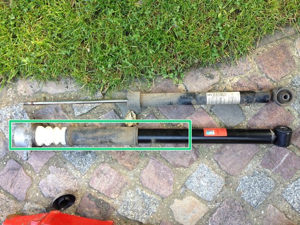 Insérer la butée et le soufflet de protection dans l'axe de l’amortisseur