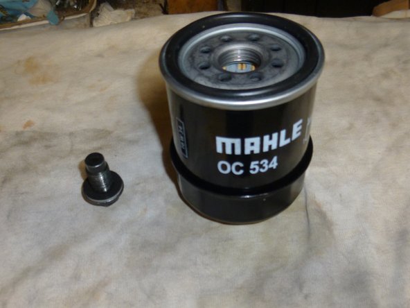 Pendant que la vieille huile s'écoule, préparer votre filtre à huile et votre bouchon en lui mettant un joint neuf.