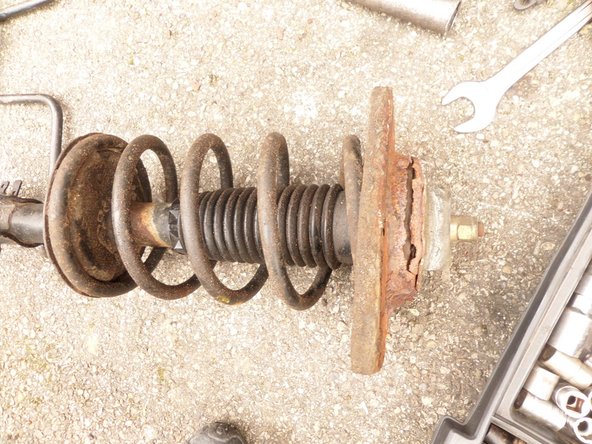 Déposer l'amortisseur (tapoter si besoin la coupelle au marteau, celle-ci peut-être légèrement collée à la caisse)