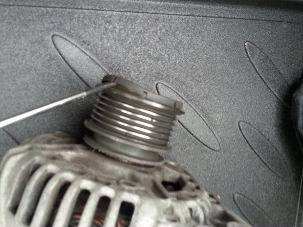 à l'aide d'un tournevis, enlever le cache en plastique de la poulie