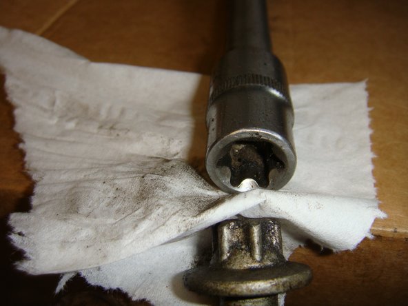 A l'aide d'un essuie tout engager  la tête de la vis dans la douille afin qu'elle soit bien maintenue