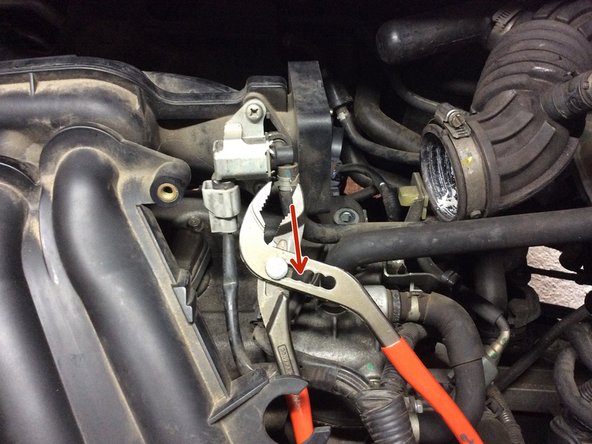 Débrancher la tubulure en haut à gauche avec une pince multiprise et celle vers le connecteur électrique.